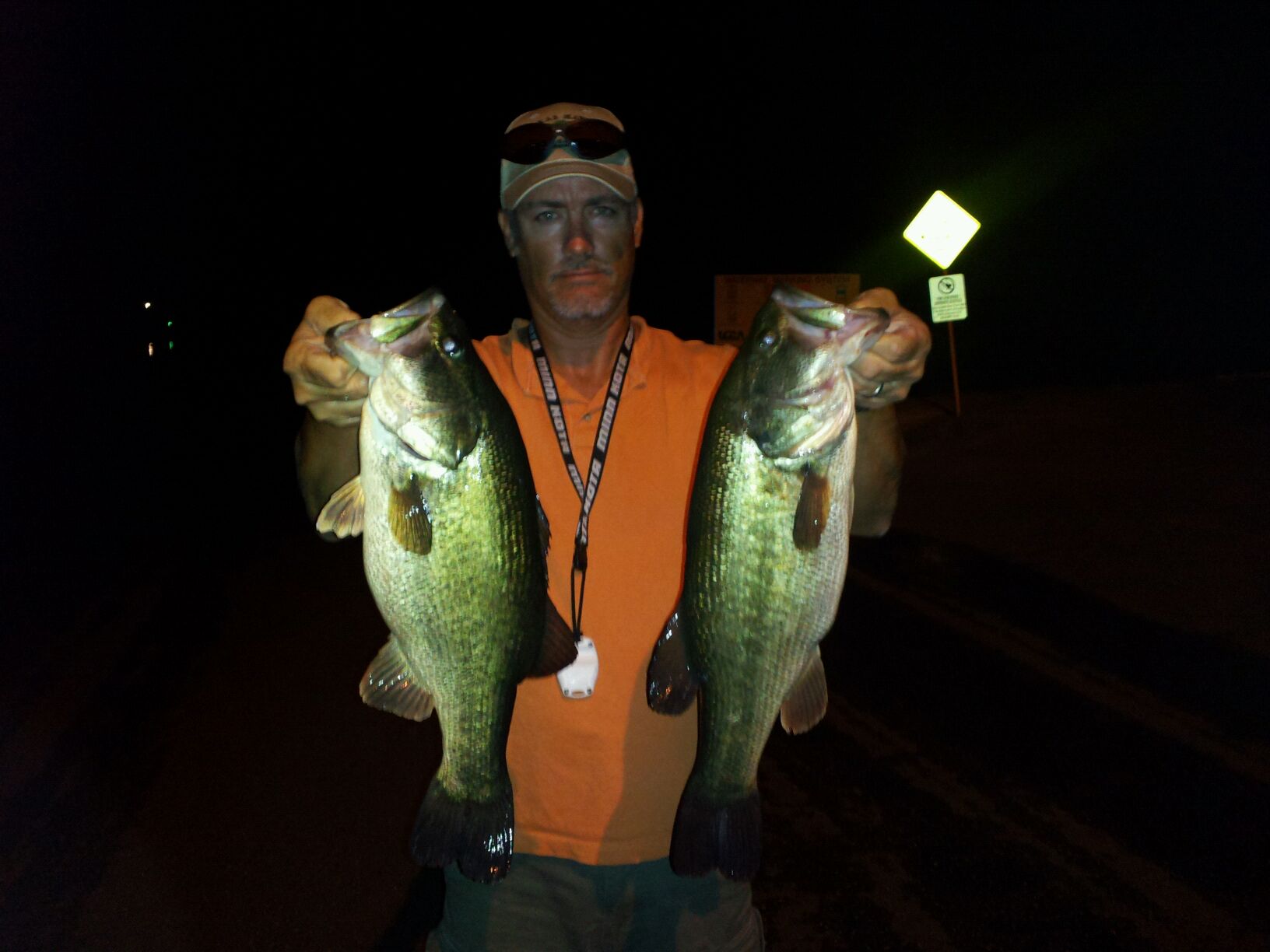 Angler with two largemouth bass caught at night on Lake Austin, July 2011