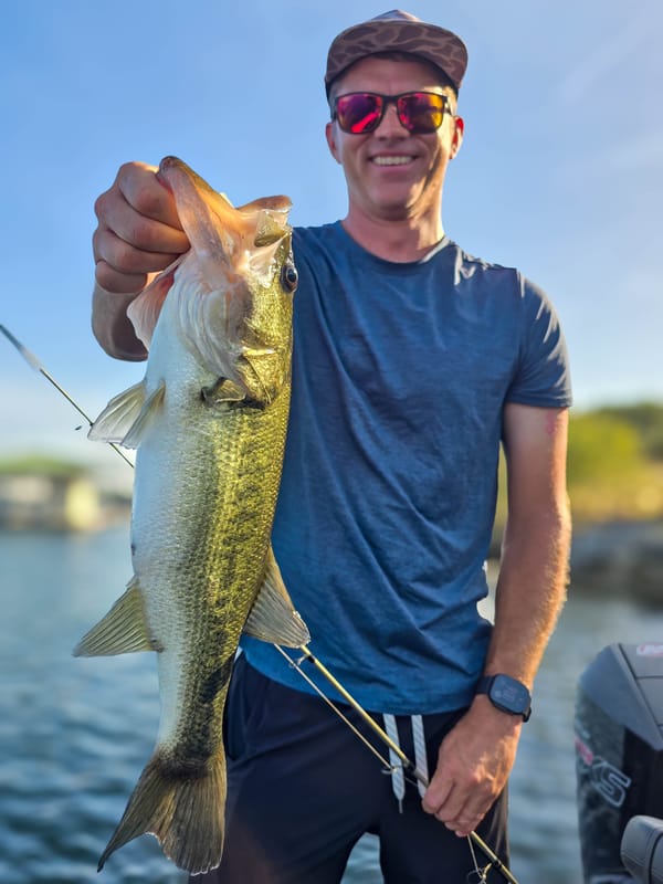 Angler holding a solid Lake Travis largemouth bass caught on a Texas-rigged worm
