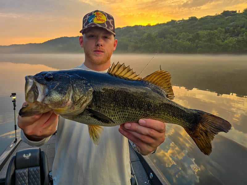 Isaac with a chunky Lake Austin largemouth bass at foggy sunrise