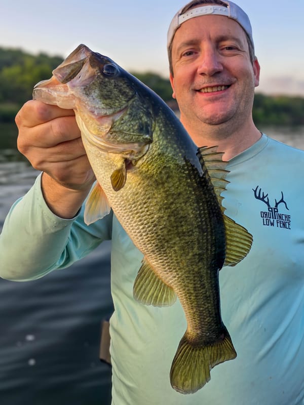 Happy client holding up a chunky Lake Austin largemouth bass