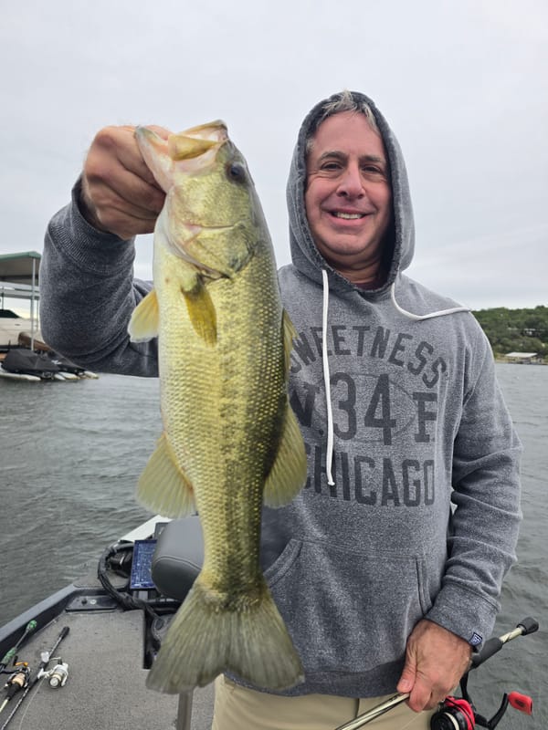 Angler with a quality Lake Travis largemouth caught near docks on a watermelon candy red creature bait